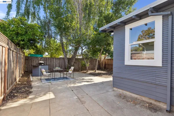 a view of backyard with table and chairs and a large tree