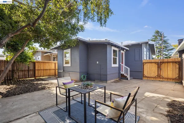 a backyard of a house with table and chairs