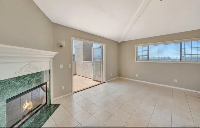 a view of an empty room with a fireplace and a window