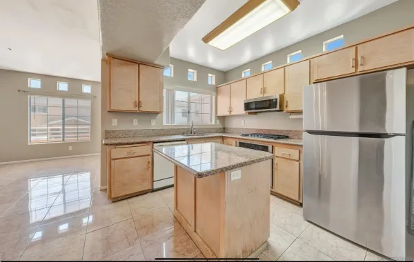 a kitchen with a refrigerator a sink and a stove top oven