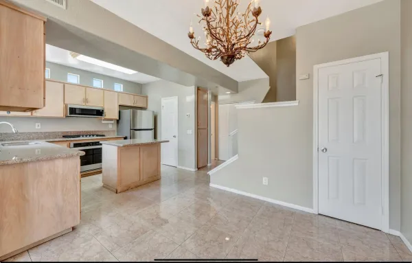 a kitchen with stainless steel appliances granite countertop a refrigerator a stove and a sink