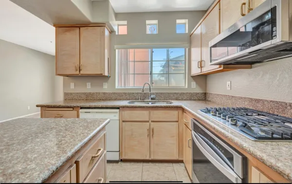 a kitchen with stainless steel appliances granite countertop a sink stove and cabinets
