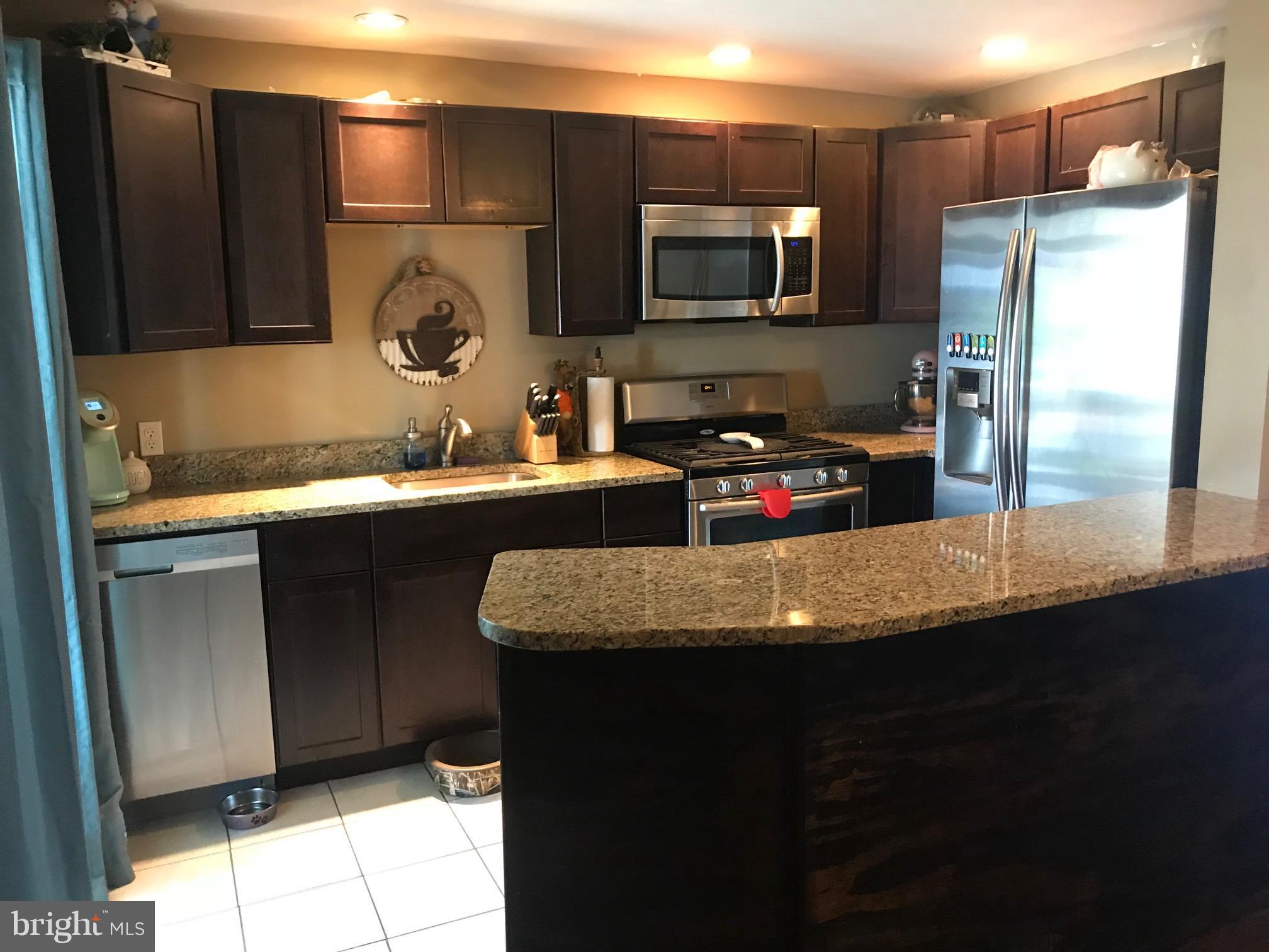 8180 Del Haven Road Baltimore, MD 21222 - Photo 6 of 29 a kitchen with stainless steel appliances granite countertop a sink refrigerator and microwave