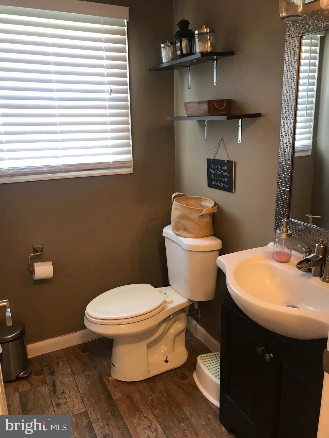 8180 Del Haven Road Baltimore, MD 21222 - Photo 10 of 29 a bathroom with a sink a toilet and a mirror