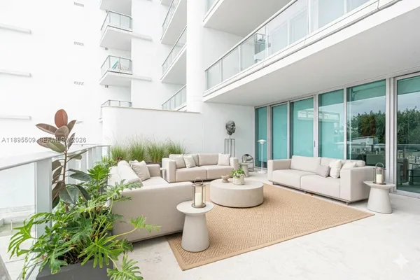 a living room with patio furniture and a potted plant