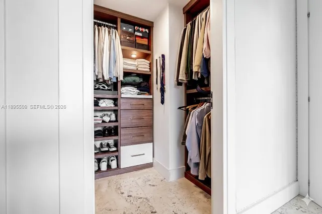 a view of walk in closet with clothes and shoes