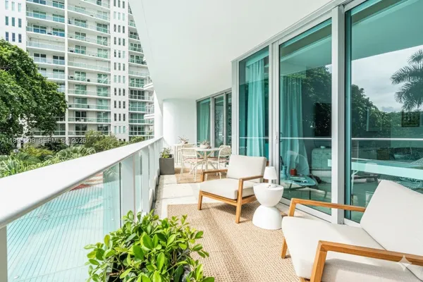 a balcony with couple of chairs and a couch