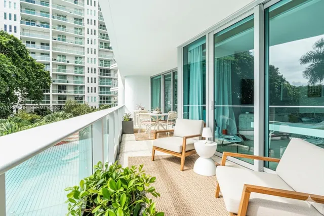 a balcony with couple of chairs and a couch