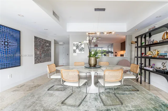 a dining room with furniture and a potted plant