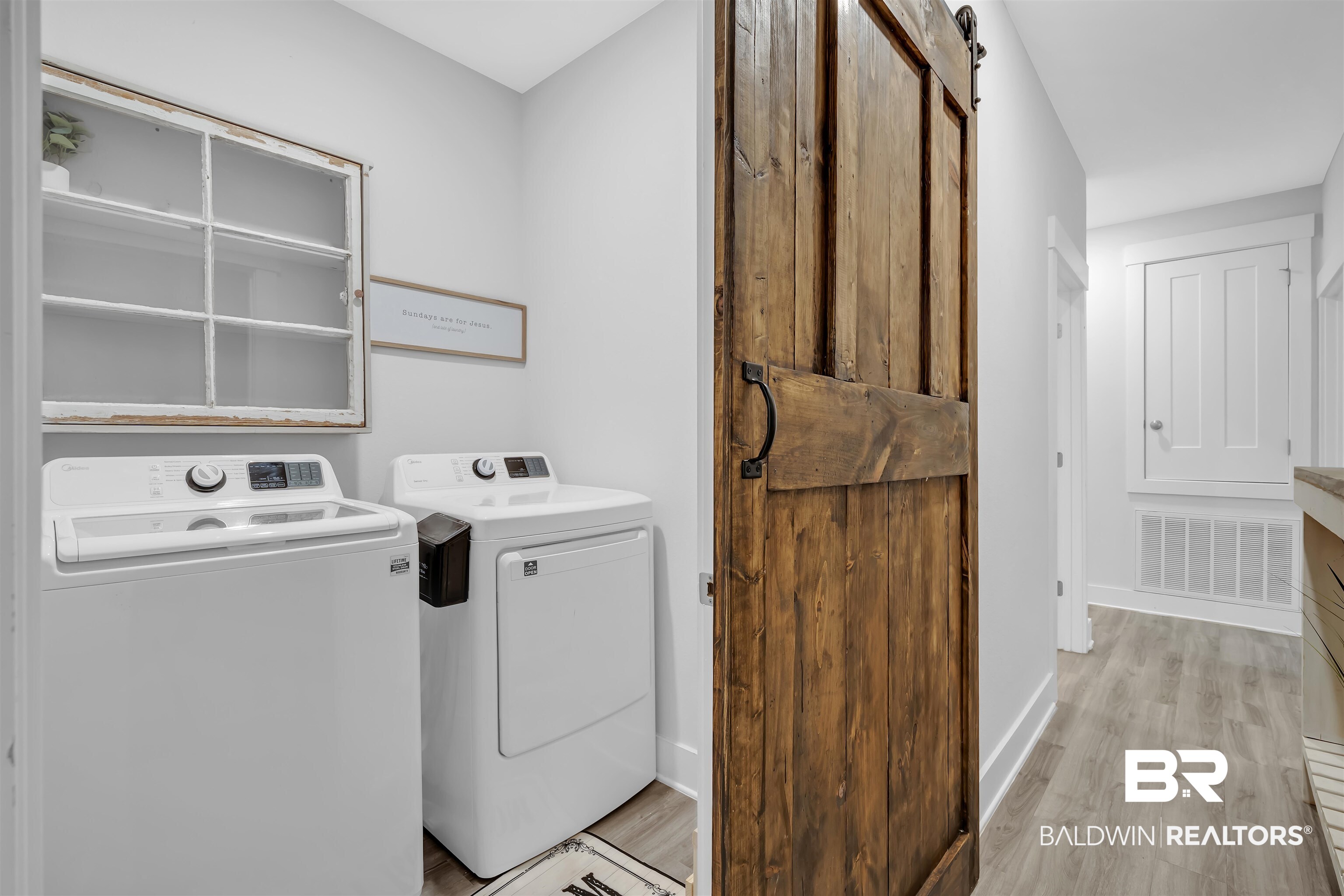 16504 Prado Loop Loxley, AL 36551 - Photo 23 of 45 Laundry room featuring a barn door, light wood-type flooring, and washer and dryer