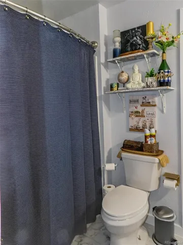 a bathroom with a toilet and a shower curtain