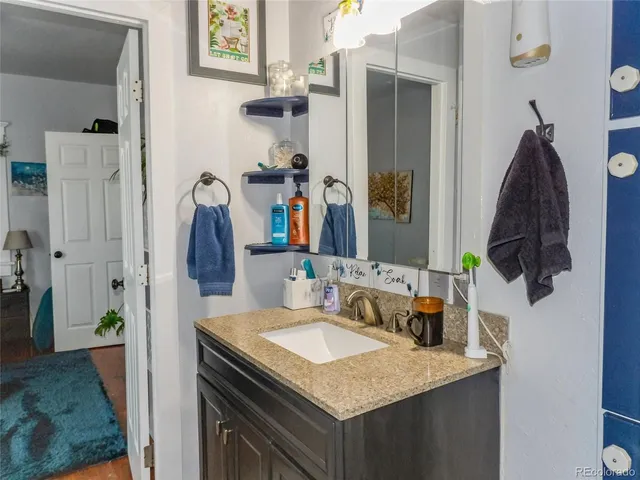 a bathroom with a granite countertop sink and a mirror