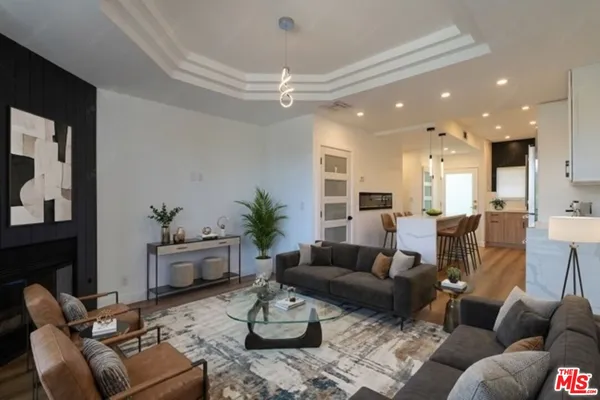 a living room with furniture couches and a dining table with kitchen view