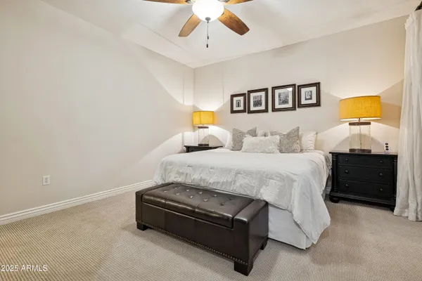 a spacious bedroom with a bed and a painting on the wall