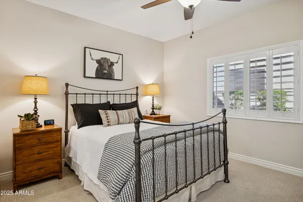 a bedroom with a bed and a lamp on the dresser