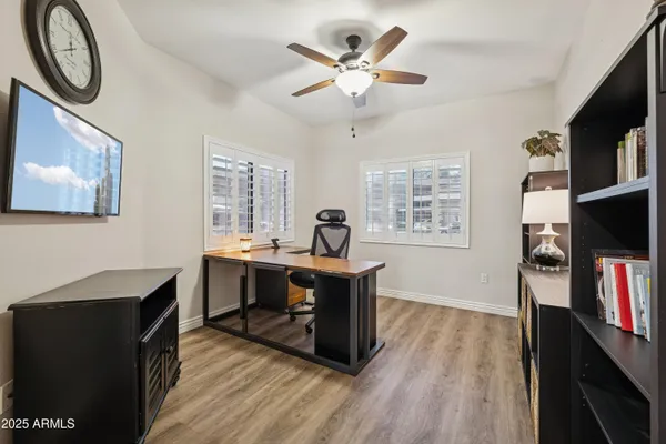 a work room with furniture a flat screen tv and a window