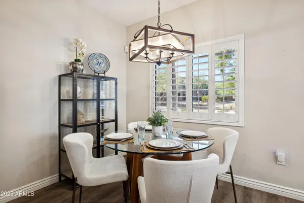a view of a dining room with furniture a chandelier and wooden floor