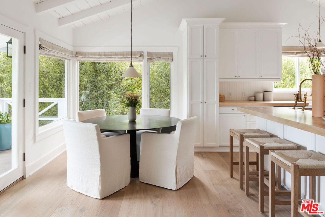 6456 Sycamore Meadows Drive Malibu, CA 90265 - Photo 10 of 29 a kitchen with stainless steel appliances granite countertop a stove top oven a sink a dining table and chairs