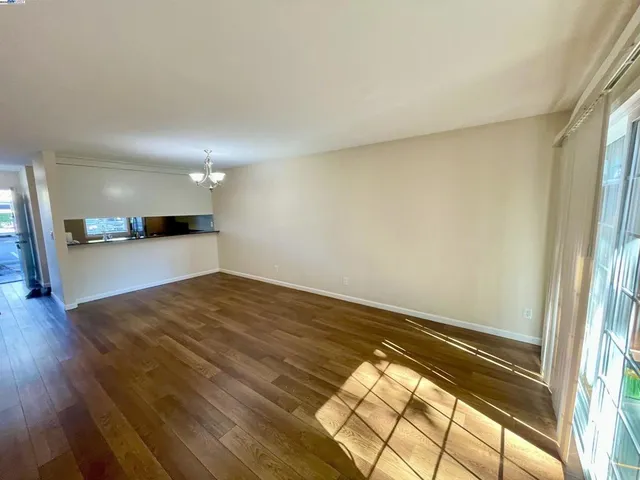 a view of a room with wooden floor and a window