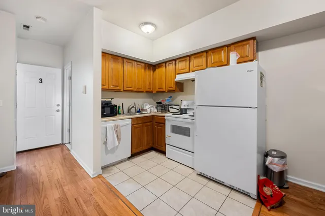 a kitchen with white cabinets and white appliances
