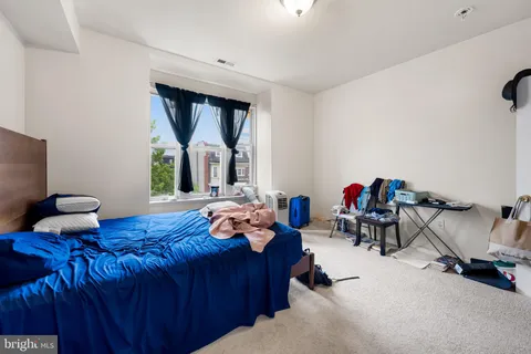 a bedroom with furniture and a large window