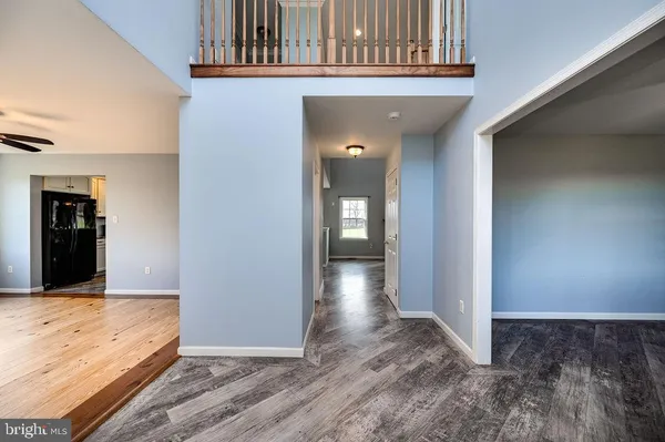 a kitchen with stainless steel appliances granite countertop wooden cabinets and a wooden floor