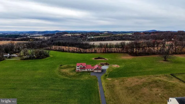 a view of a hallway with wooden floor and a living room