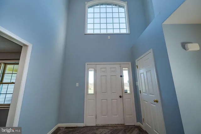 a view of empty room with wooden floor and ceiling fan