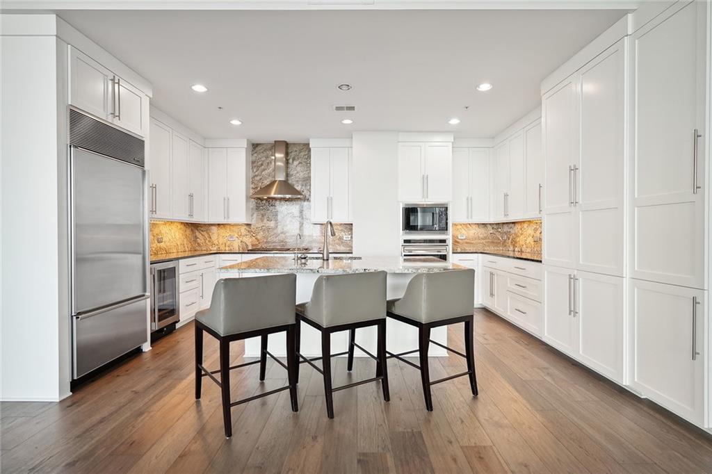 3344 Peachtree Road Northeast, Unit 3202 Atlanta, GA 30326 - Photo 13 of 39 a kitchen with a dining table chairs refrigerator and cabinets