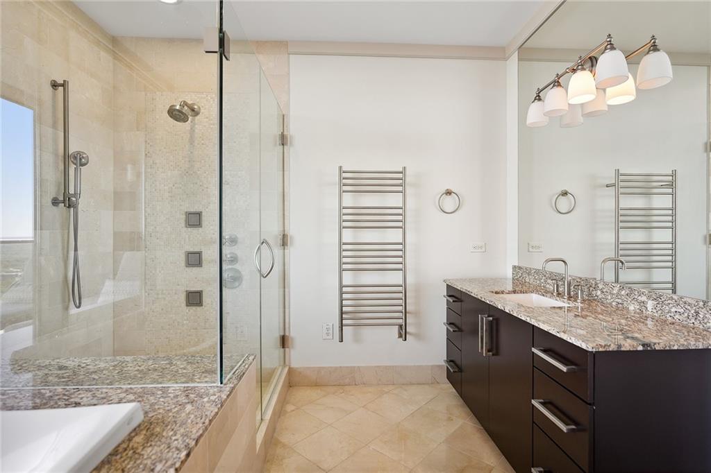 3344 Peachtree Road Northeast, Unit 3202 Atlanta, GA 30326 - Photo 28 of 39 a bathroom with a granite countertop sink a shower and a mirror