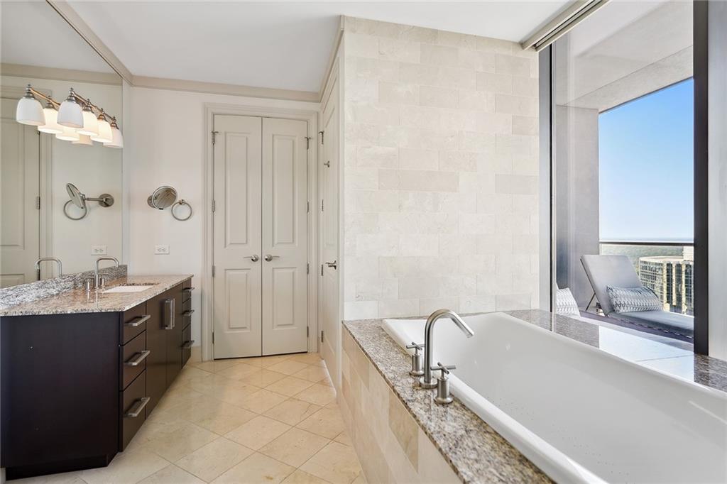 3344 Peachtree Road Northeast, Unit 3202 Atlanta, GA 30326 - Photo 30 of 39 a bathroom with a tub sink and mirror