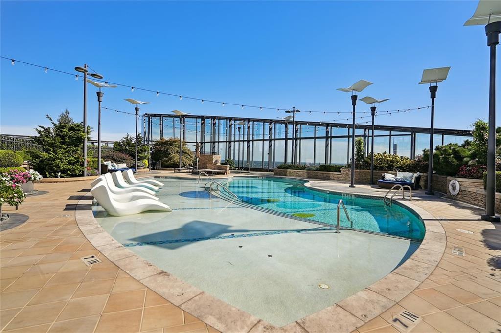 3344 Peachtree Road Northeast, Unit 3202 Atlanta, GA 30326 - Photo 34 of 39 a swimming pool with outdoor seating and yard
