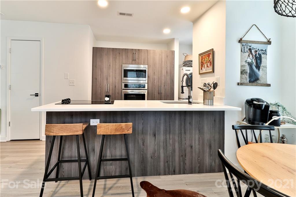 1537 Briar Creek Road, Unit A Charlotte, NC 28205 - Photo 11 of 30 a kitchen with a dining table chairs and cabinets