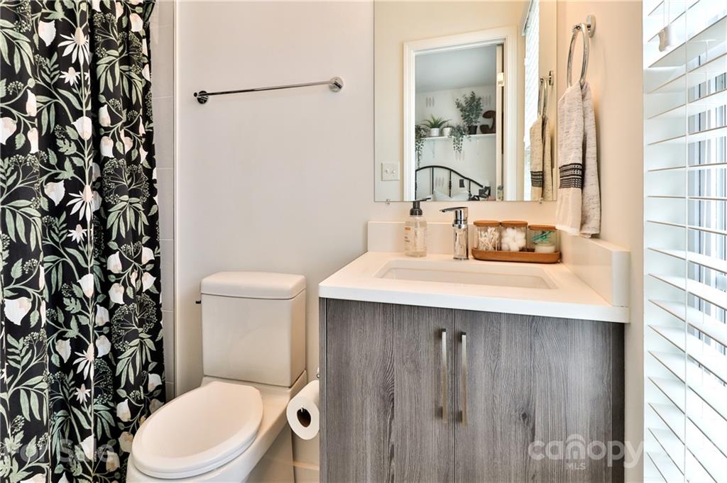 1537 Briar Creek Road, Unit A Charlotte, NC 28205 - Photo 22 of 30 a bathroom with a sink a toilet a shower and a mirror