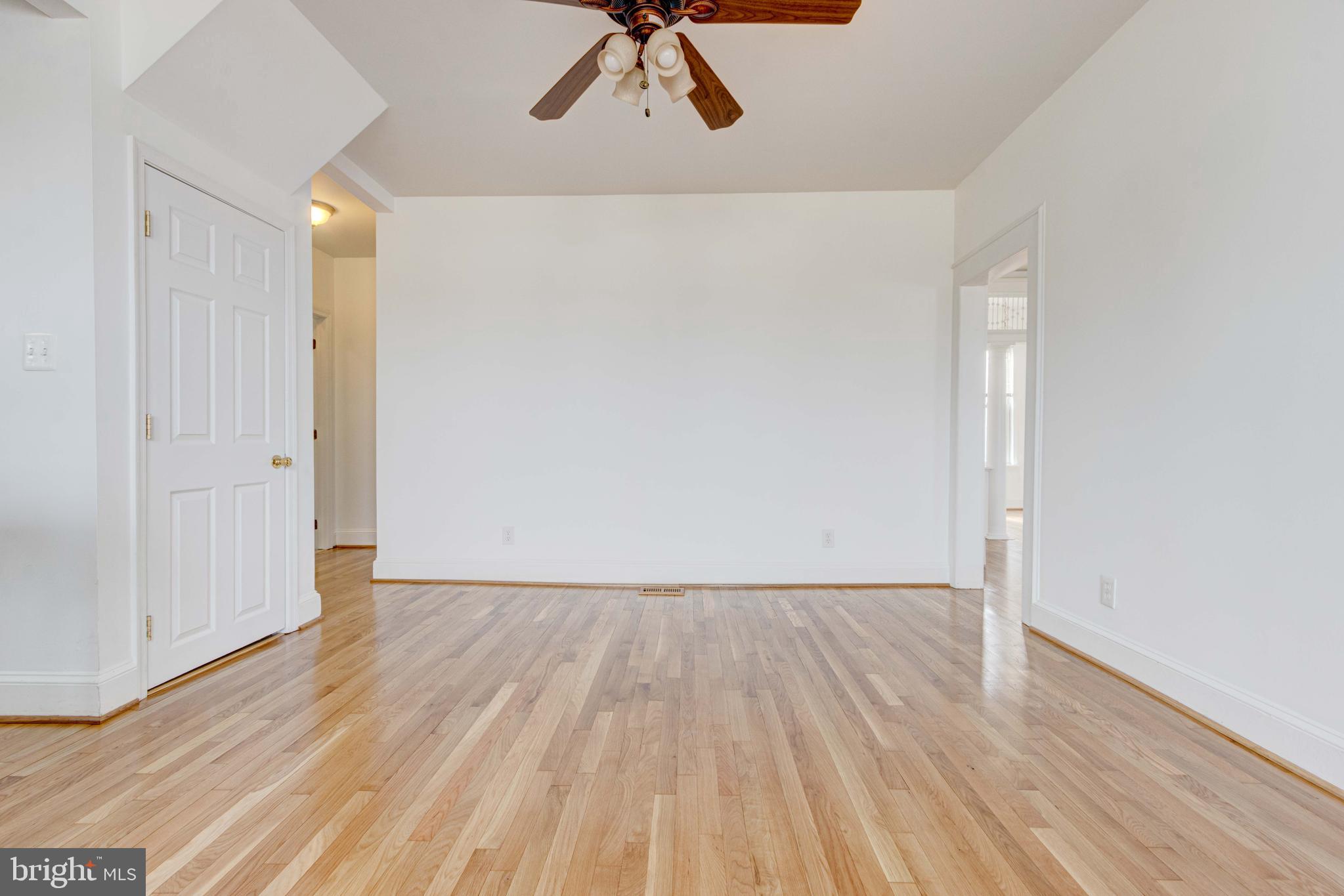 2025 Northeast Ne Baltimore, MD 21227 - Photo 105 of 122 a view of an empty room with wooden floor and a ceiling fan