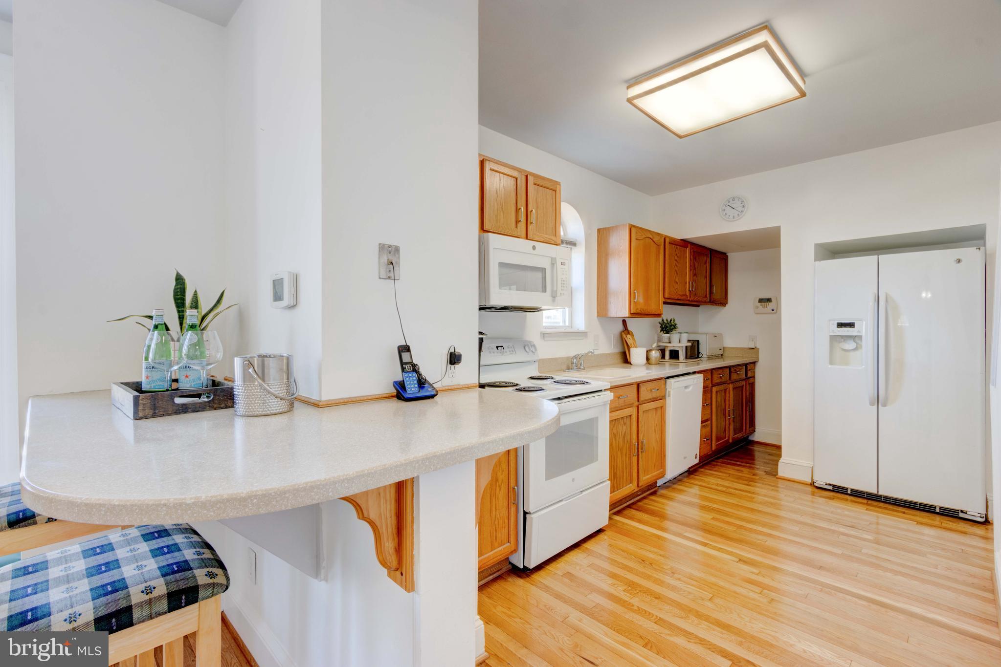 2025 Northeast Ne Baltimore, MD 21227 - Photo 36 of 122 a kitchen with stainless steel appliances granite countertop a sink dishwasher stove and refrigerator with wooden floor