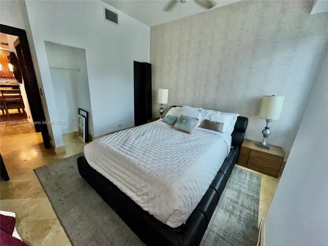 a large bed sitting in a bedroom next to a window