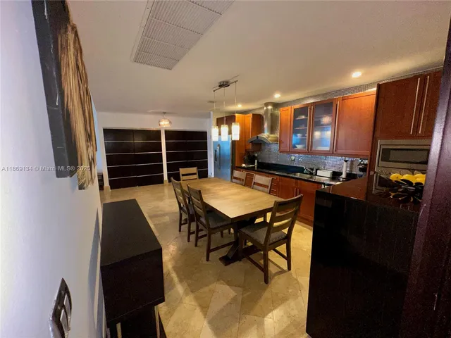 a kitchen with a table chairs a stove and a refrigerator