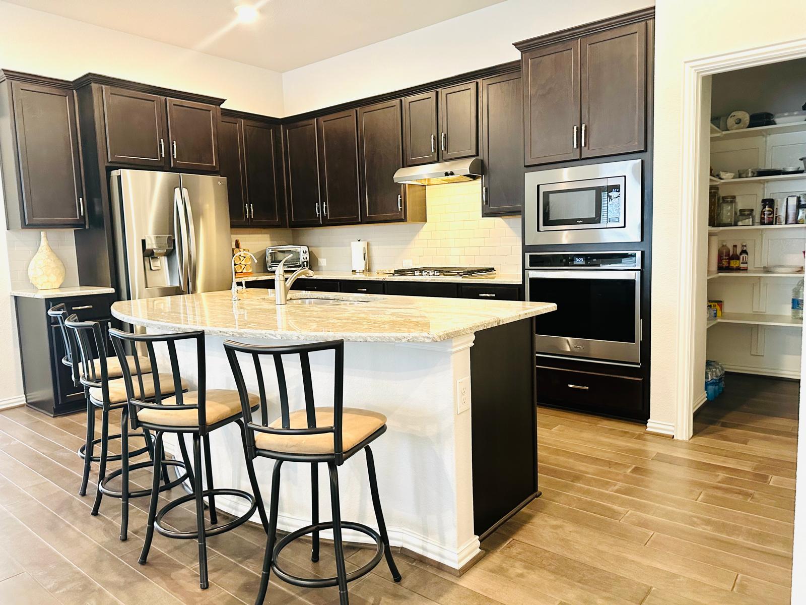 862 Leadtree Loop Buda, TX 78610 - Photo 12 of 40 a kitchen with stainless steel appliances granite countertop a refrigerator a stove a sink and dishwasher