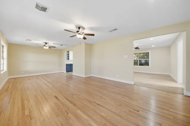 a view of an empty room and window with wooden floor