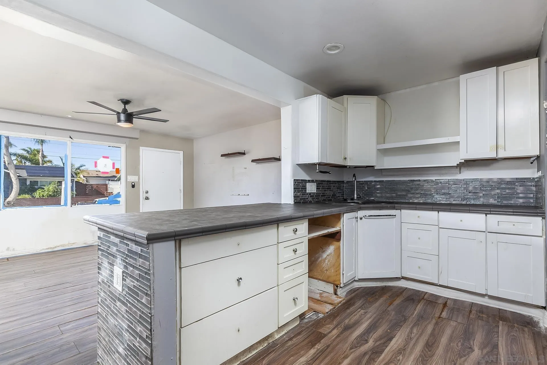 4539 Gila Avenue San Diego, CA 92117 - Photo 8 of 27 a kitchen with granite countertop white cabinets and white appliances