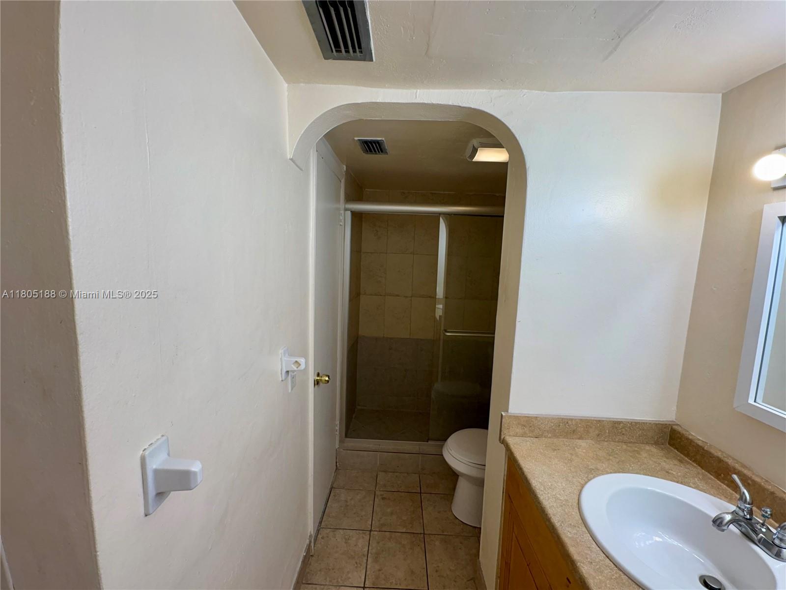 Fifth Moorings Condominium Miami, FL 33179 - Photo 15 of 29 a bathroom with a granite countertop toilet sink and mirror