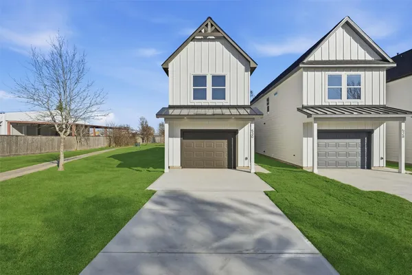 a front view of a house with a garden and yard