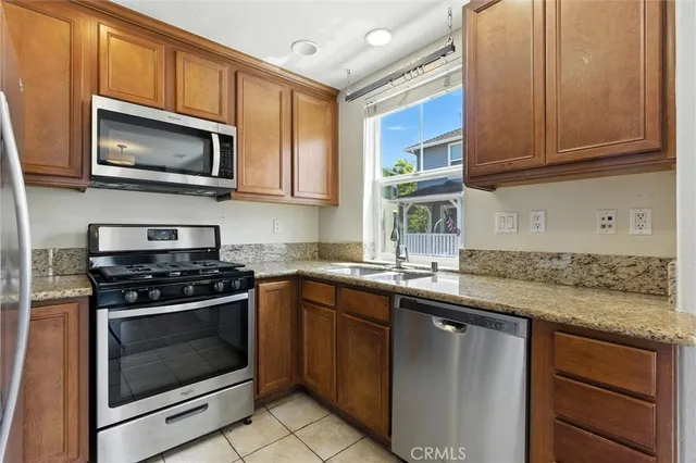 a kitchen with stainless steel appliances granite countertop a stove microwave and sink