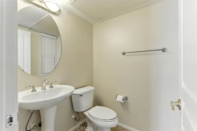 a bathroom with a sink toilet and a mirror