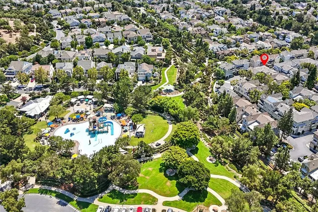 an aerial view of residential houses with outdoor space and trees