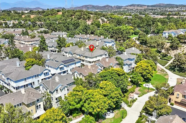 an aerial view of residential houses with outdoor space and trees all around