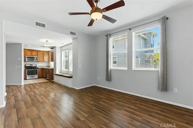a view of an empty room with window and wooden floor
