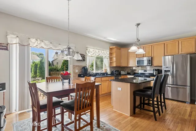 a kitchen with a dining table chairs and refrigerator
