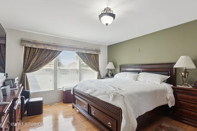 a bedroom with a bed next to a window and a chandelier
